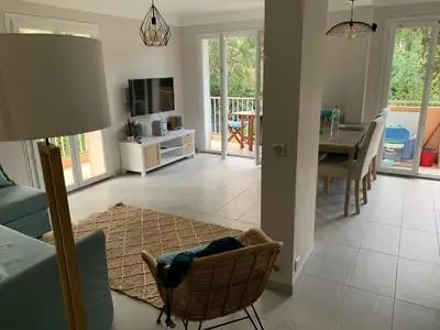 a living room with a table and a dining room at Le jasmin du Riou in Cannes