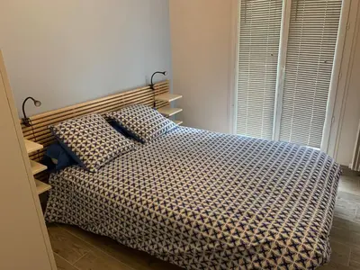 a bedroom with a bed with a checkered blanket at Le jasmin du Riou in Cannes
