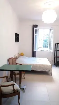 a bedroom with a bed and a table and a chair at Grand studio de 30m2 !central !spacieux !différent ! in Cannes