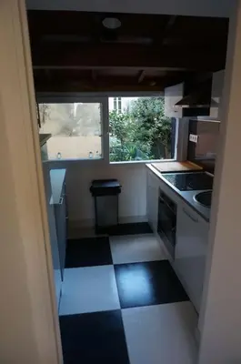 a small kitchen with a black and white tile floor at Grand studio de 30m2 !central !spacieux !différent ! in Cannes
