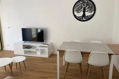 a dining room with a table and chairs and a tv at Beautiful family cocoon of 65 m close to the sea in Cannes