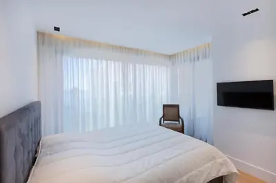 a bedroom with a bed and a flat screen tv at Apartment Lara Light apartment with an incredible view in Cannes