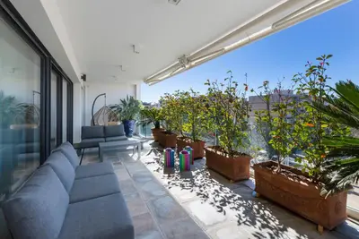 a living room with a couch and some potted plants at Apartment Lara Light apartment with an incredible view in Cannes
