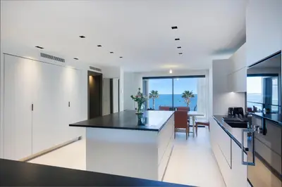 a kitchen with white cabinets and a black counter top at Apartment Lara Light apartment with an incredible view in Cannes