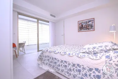 a white bedroom with a bed and a desk at Appartement Céto Superb and luminous apartment in Cannes