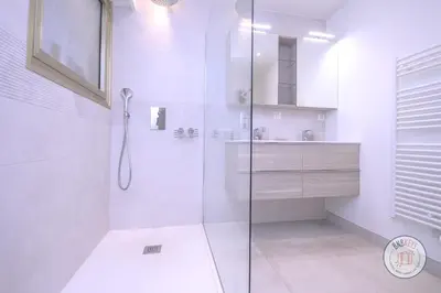 a white bathroom with a shower and a sink at Appartement Céto Superb and luminous apartment in Cannes