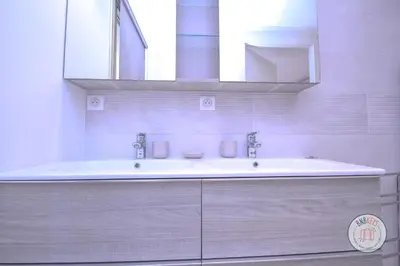 a white bathroom with a tub and a sink at Appartement Céto Superb and luminous apartment in Cannes