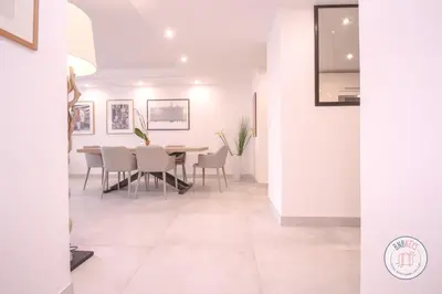 a dining room with white walls and a table and chairs at Appartement Céto Superb and luminous apartment in Cannes