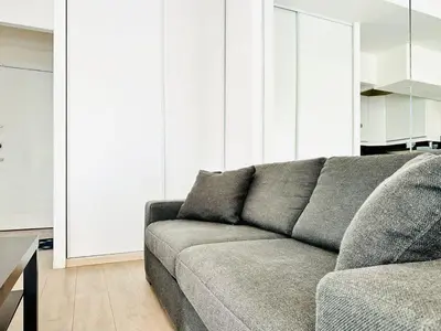 a living room with a gray couch and a table at Palm Croisette - Studio vue Mer & Martinez in Cannes