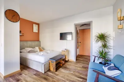 a hotel room with a bed and a couch at Magnifique studio avec terrasse au cœur de Cannes in Cannes