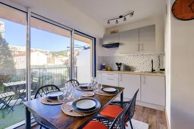 a kitchen and dining room with a table and chairs at Magnifique studio avec terrasse au cœur de Cannes in Cannes