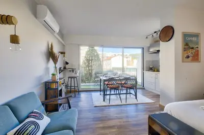 a living room with a blue couch and a table at Magnifique studio avec terrasse au cœur de Cannes in Cannes
