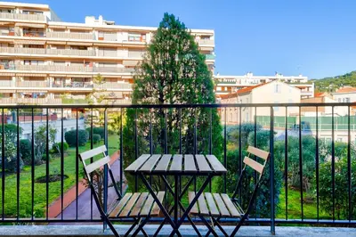 a table and chairs on a balcony with a building at Magnifique studio avec terrasse au cœur de Cannes in Cannes