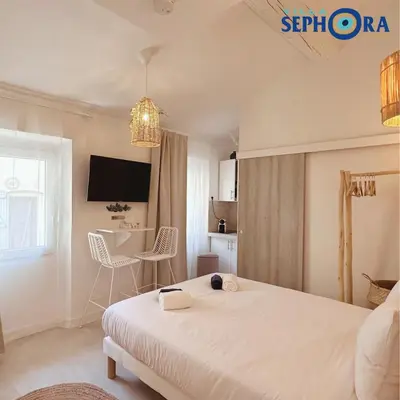 a bedroom with a bed and a table with chairs at VILLA SEPHORA CANNES in Cannes