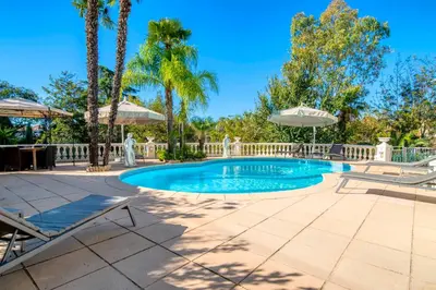 a swimming pool with two chairs and an umbrella at REF 1981 - Cannes Center - Particular town house for rent in Cannes
