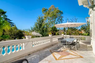 a patio with a table and an umbrella on a fence at REF 1981 - Cannes Center - Particular town house for rent in Cannes