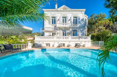 a large white house with a swimming pool in front of it at REF 1981 - Cannes Center - Particular town house for rent in Cannes