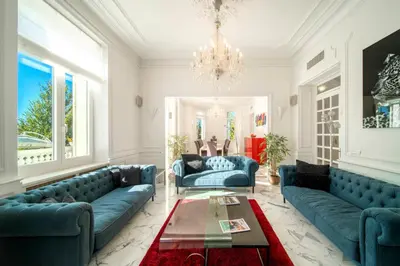 a living room with blue couches and a chandelier at REF 1981 - Cannes Center - Particular town house for rent in Cannes
