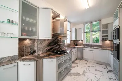 a kitchen with white cabinets and marble counter tops at REF 1981 - Cannes Center - Particular town house for rent in Cannes