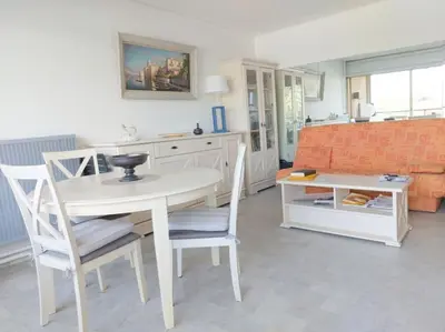a kitchen with a table and chairs and a couch at Bocca Baie T2 en bord de mer - Axelle Loc Appart in Cannes