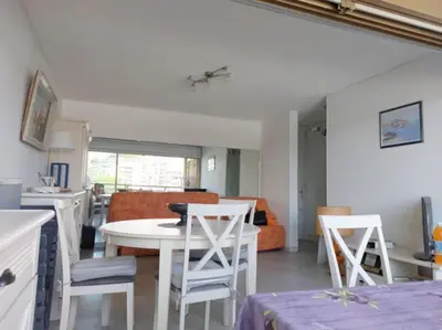 a kitchen and living room with a table and chairs at Bocca Baie T2 en bord de mer - Axelle Loc Appart in Cannes