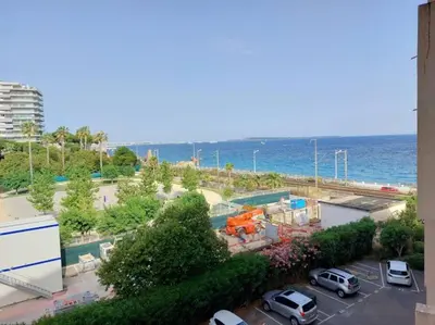 a view of a parking lot next to the ocean at Bocca Baie T2 en bord de mer - Axelle Loc Appart in Cannes