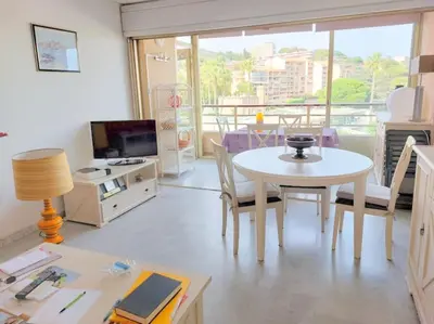 a living room with a table and a television at Bocca Baie T2 en bord de mer - Axelle Loc Appart in Cannes