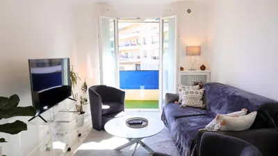 a living room with a blue couch and a tv at Proche Centre Ville, T4, Exclusivité Congrès - Palmazur Vacances in Cannes