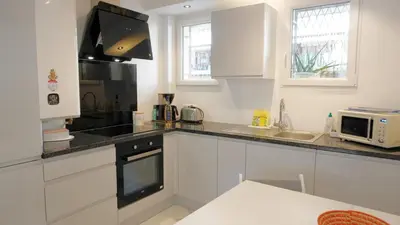 a kitchen with white cabinets and a sink and a microwave at Proche Centre Ville, T4, Exclusivité Congrès - Palmazur Vacances in Cannes