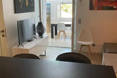 a living room with a tv and a table and chairs at WE CANNES ! Résidence Gallia apartment premium two bedroom in Cannes