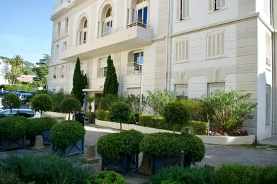 a building with a bunch of bushes in front of it at WE CANNES ! Résidence Gallia apartment premium two bedroom in Cannes