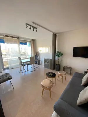 a living room with a couch and a table at 3 Pièces Vue mer & Iles de Lérins in Cannes