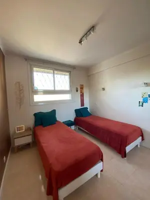 a bedroom with two beds with red sheets and a window at 3 Pièces Vue mer & Iles de Lérins in Cannes