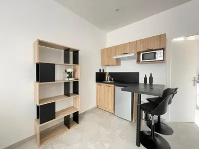 a kitchen with a counter and a table in a room at NEGRIN in Cannes