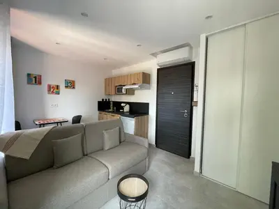 a living room with a couch and a kitchen at NEGRIN in Cannes