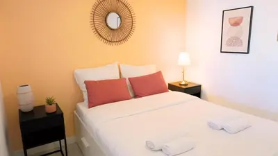a bedroom with a large white bed with orange pillows at Proche Palais Des Festivals,Croisette - Hyper centre - Palmazur Vacances in Cannes