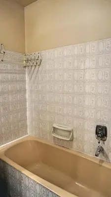 a bath tub in a bathroom with white tiles at Proche Croisette, T2 avec terrasse, By Palmazur in Cannes