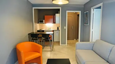 a living room with a couch and a kitchen at Proche Croisette, T2 avec terrasse, By Palmazur in Cannes