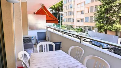 a table and chairs on a balcony with a view of a street at Proche Croisette, T2 avec terrasse, By Palmazur in Cannes