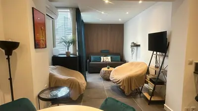 a living room with a couch and a table at appartement Carré d’or 2 pas de la croisette in Cannes
