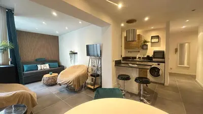 a living room with a couch and a table in a room at appartement Carré d’or 2 pas de la croisette in Cannes