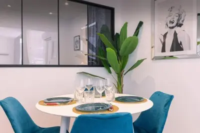 a table with blue chairs and a white table with wine glasses at appartement Carré d’or 2 pas de la croisette in Cannes