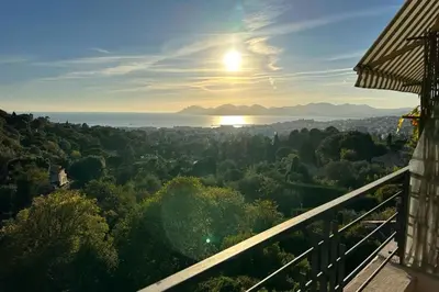 a view of the sun setting over a city at WE CANNES ! Amazing Sea View 2 Bedrooms La Vista in Cannes