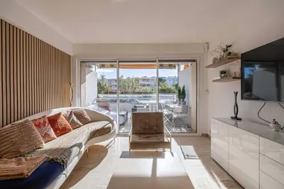 a living room with a couch and a television at Charming apartment on Boulevard Alexandre III in Cannes