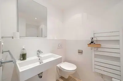 a white bathroom with a sink and a toilet at Charming apartment on Boulevard Alexandre III in Cannes
