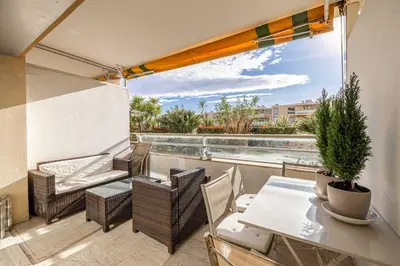 a balcony with a table and chairs and a view at Charming apartment on Boulevard Alexandre III in Cannes