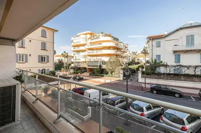 an apartment balcony with cars parked on a street at Charming apartment on Boulevard Alexandre III in Cannes