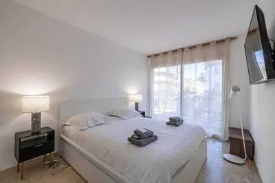 a white bedroom with a bed with towels on it at Charming apartment on Boulevard Alexandre III in Cannes