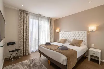 a bedroom with a large bed and a large window at Splendid apartment, Sea view, Parking - Croisette in Cannes