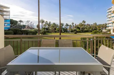 a table and chairs on a balcony with palm trees at Splendid apartment, Sea view, Parking - Croisette in Cannes
